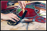Lisa Maywood - stained glass artist working on a custom piece of glass art